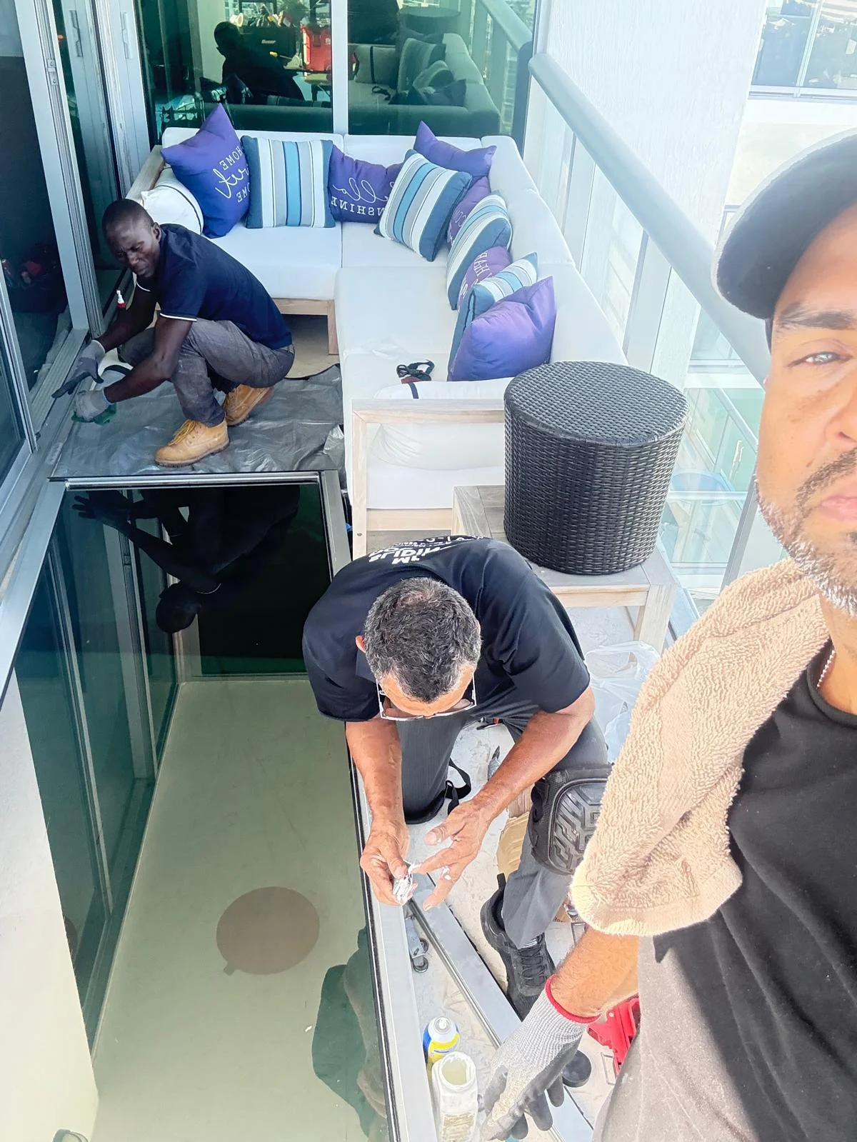 Team performing sliding door and glass service on a balcony