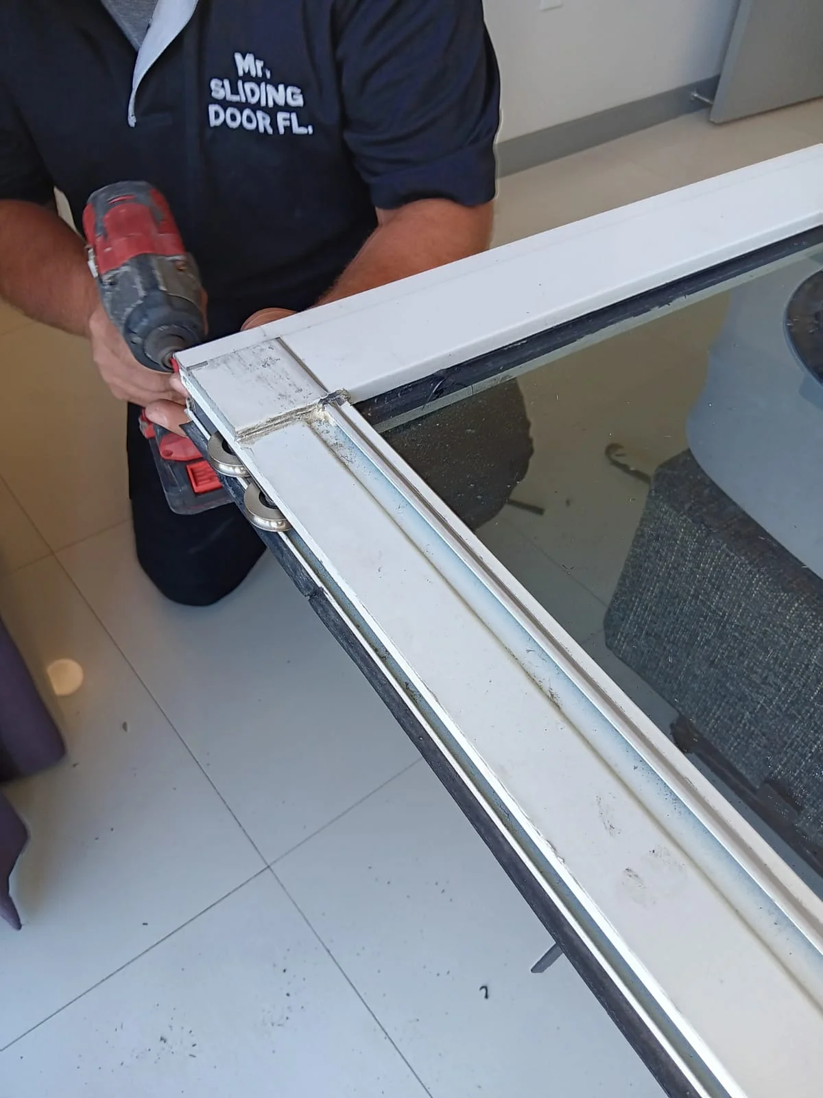 Close-up of a sliding door panel being serviced and fitted with new rollers